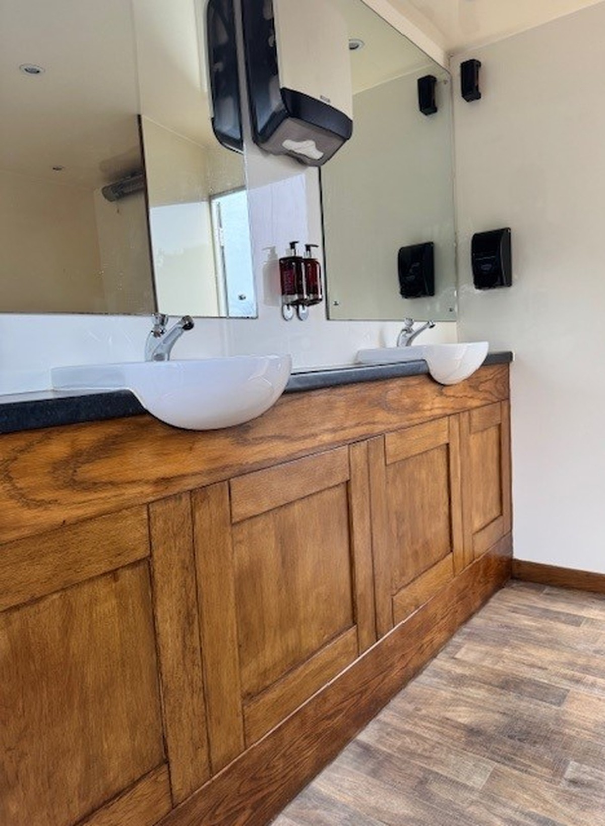 Sinks and mirrors in a block of luxury, outdoor toilets.