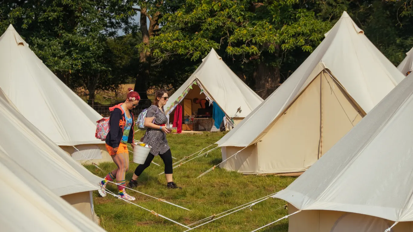 Glamping village near Lytham Festival with spacious tents, real beds, solar lighting, and modern facilities including a pamper room and bar.
