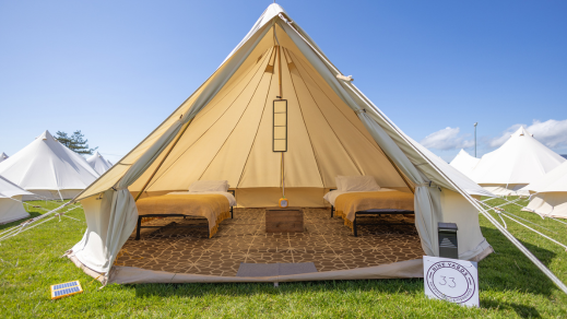 Interior of a glamping tent on the Isle of Man set up for the TT Races, featuring real beds with cosy bedding, solar lighting inside and out, both spacious and comfortable.