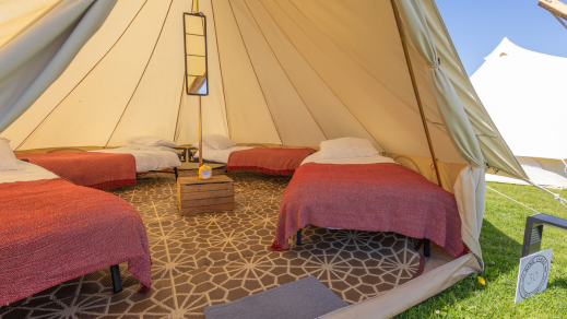 Luxury glamping accommodation tent interior at the Isle of Man TT Races with real beds and cosy bedding.
