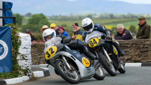 Two classic motorbikes racing on the Billown Circuit during the Pre-TT Classic Races in Castletown, Isle of Man.