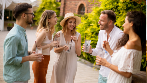 Well-dressed people socializing outdoors at a glamping village.